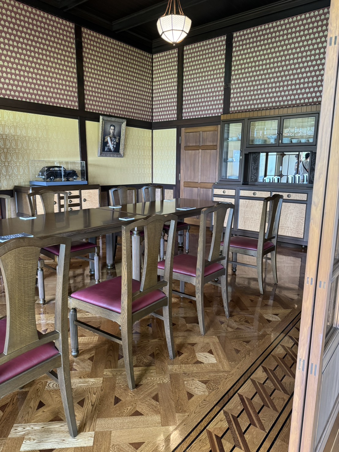 文様のある壁と木製家具を備えた荻外荘の食堂